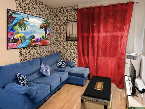 un soggiorno con un divano blu e tende rosse di PUERTA DEL SOL Carretas APARTAMENTS & Rooms a Madrid