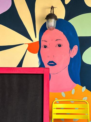 uma pintura de uma mulher com uma luz na cabeça em Black Tomato Hostel Kutaisi em Kutaisi