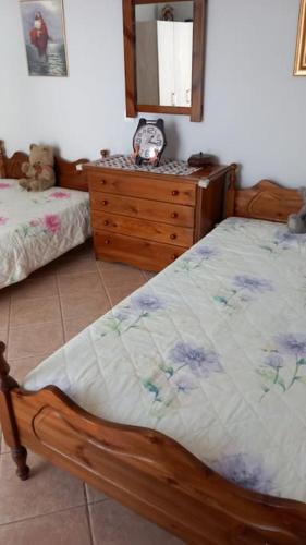 a bedroom with a bed and a dresser with a mirror at AMAZING VIEW IN ANTHIDONA in Loukísia