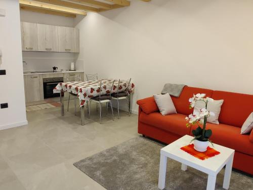a living room with a red couch and a table at Casa Venere in Ospedaletto