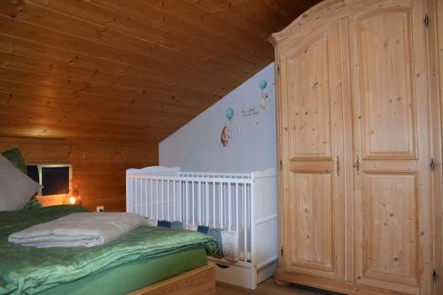 1 dormitorio con cama y techo de madera en Am Bergangerl, en Ettal