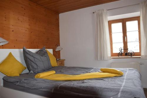 a bedroom with a bed with a yellow blanket on it at Am Bergangerl in Ettal