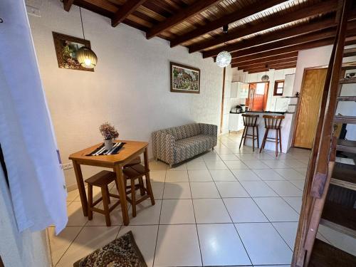 a living room with a table and a chair at Chalé da Lu in Santo Antônio do Pinhal