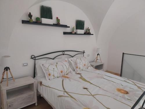 um quarto com uma cama e duas prateleiras na parede em CASA VACANZE DAHLIA em Catânia