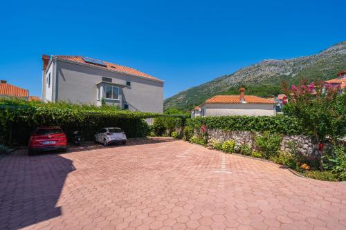a brick driveway with cars parked in front of a house at Apartments Villa Key in Cavtat