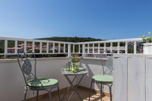 a patio with two chairs and a table on a balcony at Apartments Villa Key in Cavtat