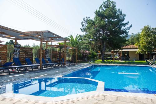 uma piscina com cadeiras azuis e uma casa em Villa Vasiliadi em Vourvourou