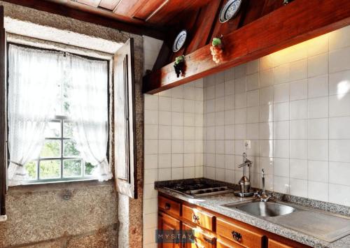 cocina con fregadero y ventana en MyStay - Casa de Abbades, en Gandra