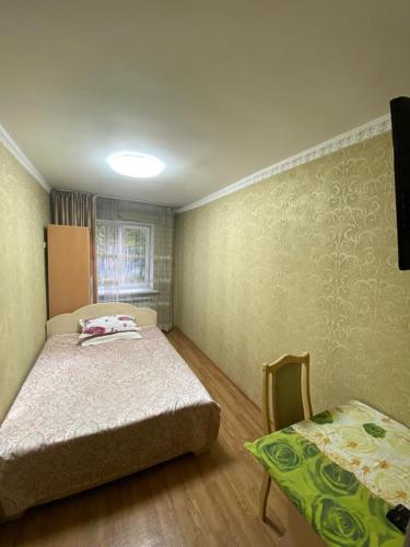 um quarto com duas camas e uma mesa e uma cama em 3 комнатная квартира Аэропорт em Turksib