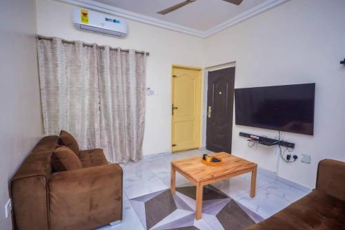 a living room with a couch and a coffee table at BH Apartment in Kasoa