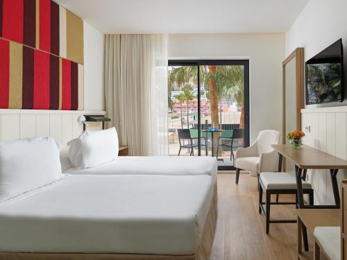 a hotel room with a bed and a table and chairs at H10 Casa del Mar in Santa Ponsa