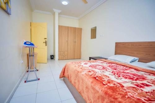 a bedroom with a bed and a stool in it at BH Apartment in Kasoa