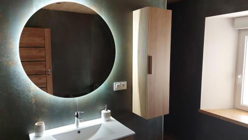 a bathroom with a sink and a mirror at LE NID DES PLANCHETTES - Suite Chambres d'Hôtes 