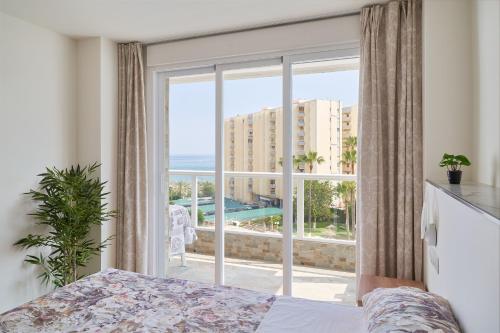 a bedroom with a large window with a view of the ocean at Apartamento HAPPY DAYS- Diana 1 in Benalmádena