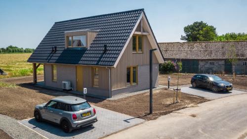a small house with two cars parked in front of it at EuroParcs Cadzand-Bad in Cadzand