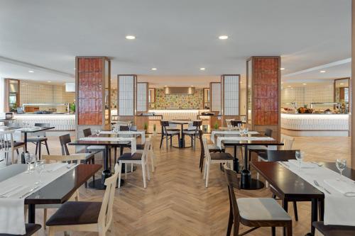 a restaurant with tables and chairs and a bar at H10 Casa del Mar in Santa Ponsa