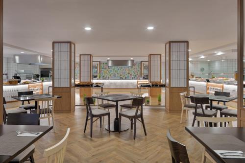 a restaurant with tables and chairs and a kitchen at H10 Casa del Mar in Santa Ponsa