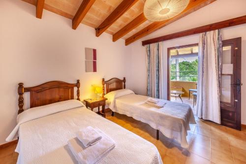 a bedroom with two beds and a window at Villa Antonia in El Port