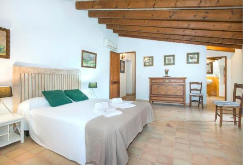 een slaapkamer met een wit bed en een houten plafond bij Son March Petite in Pollença