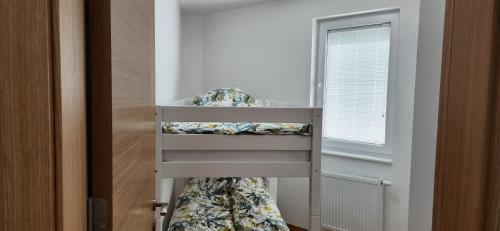 ein Schlafzimmer mit einem Etagenbett in einem Zimmer mit einem Fenster in der Unterkunft Brand New Two Bedroom and One Living Room Apartment in a Great Location! in Sarajevo
