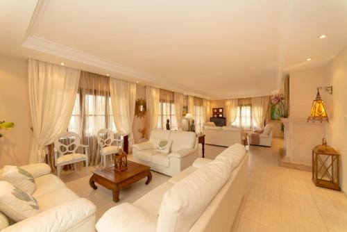 ein großes Wohnzimmer mit weißen Sofas und Stühlen in der Unterkunft Oliveres in El Port