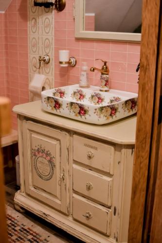 a bathroom with a sink with a flower pattern on it at Osada Między Drzewami in Braniewo