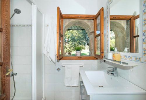a bathroom with a sink and a mirror and a window at Can Reus by Vintage Travel in Pollença