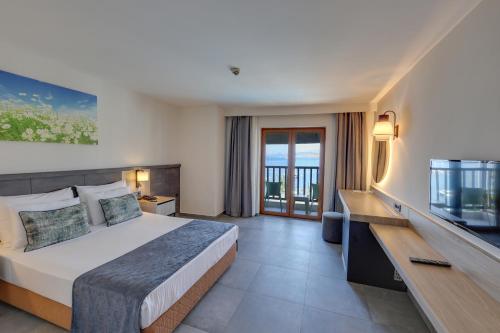 um quarto de hotel com uma cama e uma televisão em DIAMOND OF BODRUM em Bodrum City