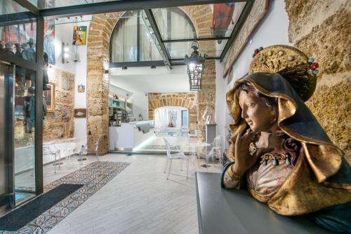 a statue of a woman sitting on a table in a room at Porta di Castro Boutique Hotel & SPA in Palermo