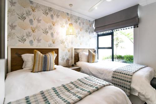 a bedroom with two beds and a window at Serendipity in Hermanus