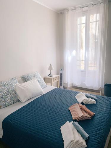 - une chambre avec un grand lit bleu et des serviettes dans l'établissement Au cœur du vieil Antibes, à Antibes