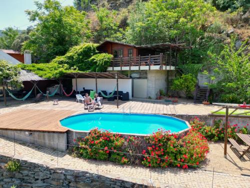 uma casa com piscina e deck de madeira em Douro Yacht Charter & Bungalows em São João da Pesqueira