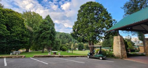 a golf cart parked in a parking lot next to a building at Gooderson Drakensberg Gardens Golf & Spa Resort in Drakensberg Garden