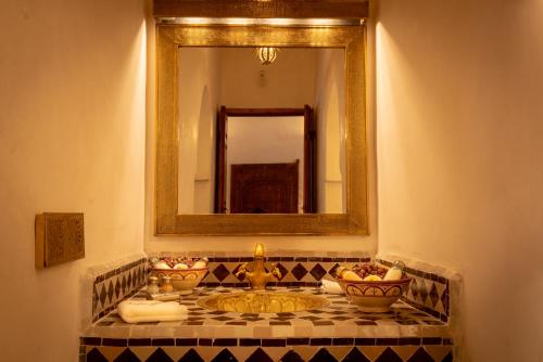 a bathroom with a sink and a mirror at Palais Aix Kabaj &Spa in Marrakech