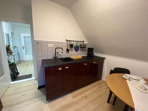 cocina con fregadero y mesa en una habitación en Haus Sunshine - Ferienwohnung Sunshine 1, en Hessisch Oldendorf