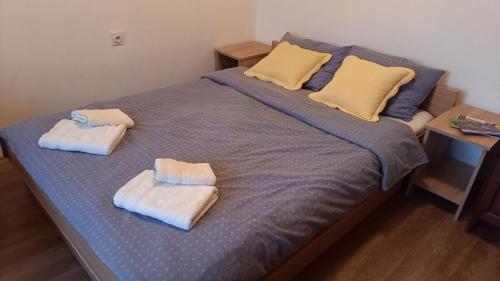 Una cama con dos toallas encima. en Šumska čarolija en Kosjerić