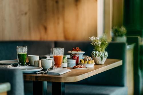 a wooden table with food and drinks on it at Luisenhöhe - Gesundheitsresort Schwarzwald in Horben