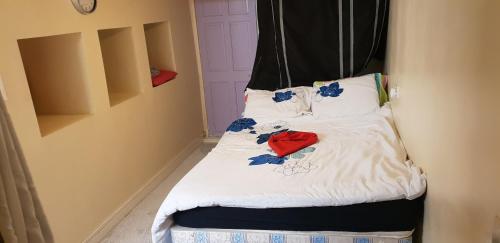 a small bed with white sheets and blue flowers on it at Joyful Place in Huddersfield