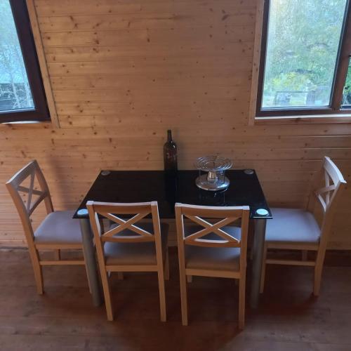 a dining room table with two chairs and a bottle of wine at cottage dzama 