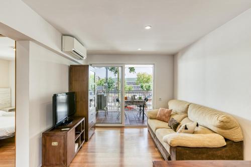 a living room with a couch and a tv at Olga in Platja  d'Aro