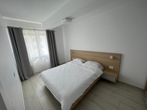 a small bedroom with a bed and a window at Cristea Residence in Oradea