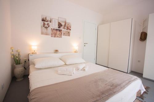 une chambre avec un lit blanc avec deux serviettes dessus dans l'établissement Stellar Suite, à Rab