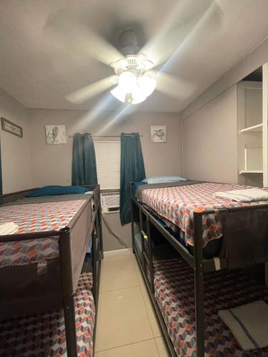 two bunk beds in a room with a ceiling fan at Miami Vibes "Hostel-Like" Shared Room in North Miami