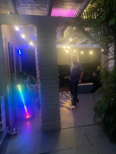 a man standing next to a brick wall with lights at Miami Vibes "Hostel-Like" Shared Room in North Miami