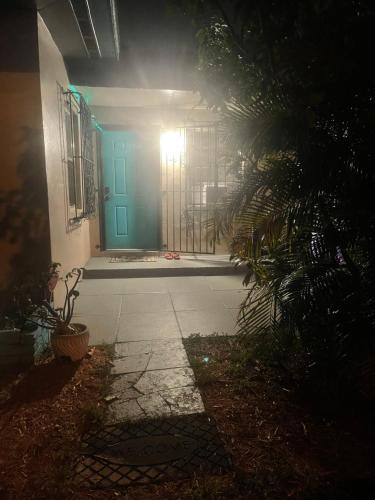 a blue door on a house at night at Miami Vibes "Hostel-Like" Shared Room in North Miami