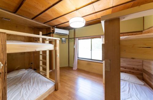 Postel nebo postele na pokoji v ubytování おせっかいゲストハウス 昭和の寅や