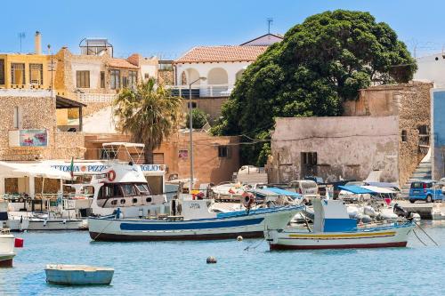 two boats are docked in a harbor with buildings at DipintodiBlu Charming House in Lampedusa