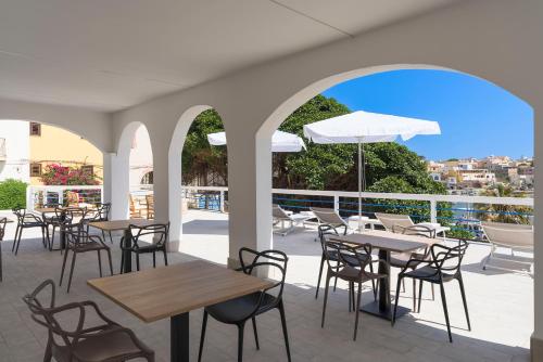 a patio with tables and chairs and an umbrella at DipintodiBlu Charming House in Lampedusa