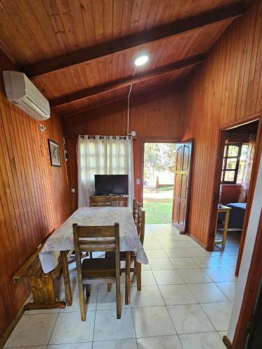 una sala da pranzo con un tavolo e sedie in una stanza di CABAÑAS PARAISO a Puerto Iguazú