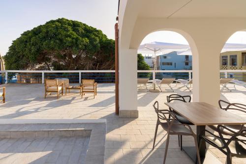 a patio with tables and chairs and a table at DipintodiBlu Charming House in Lampedusa